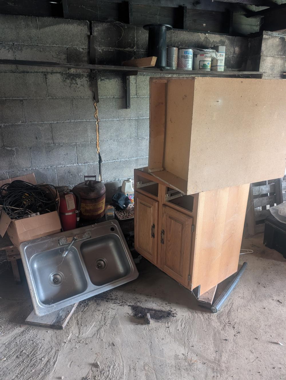 cabinets, sink, fire extinguisher, gas can, wood bench