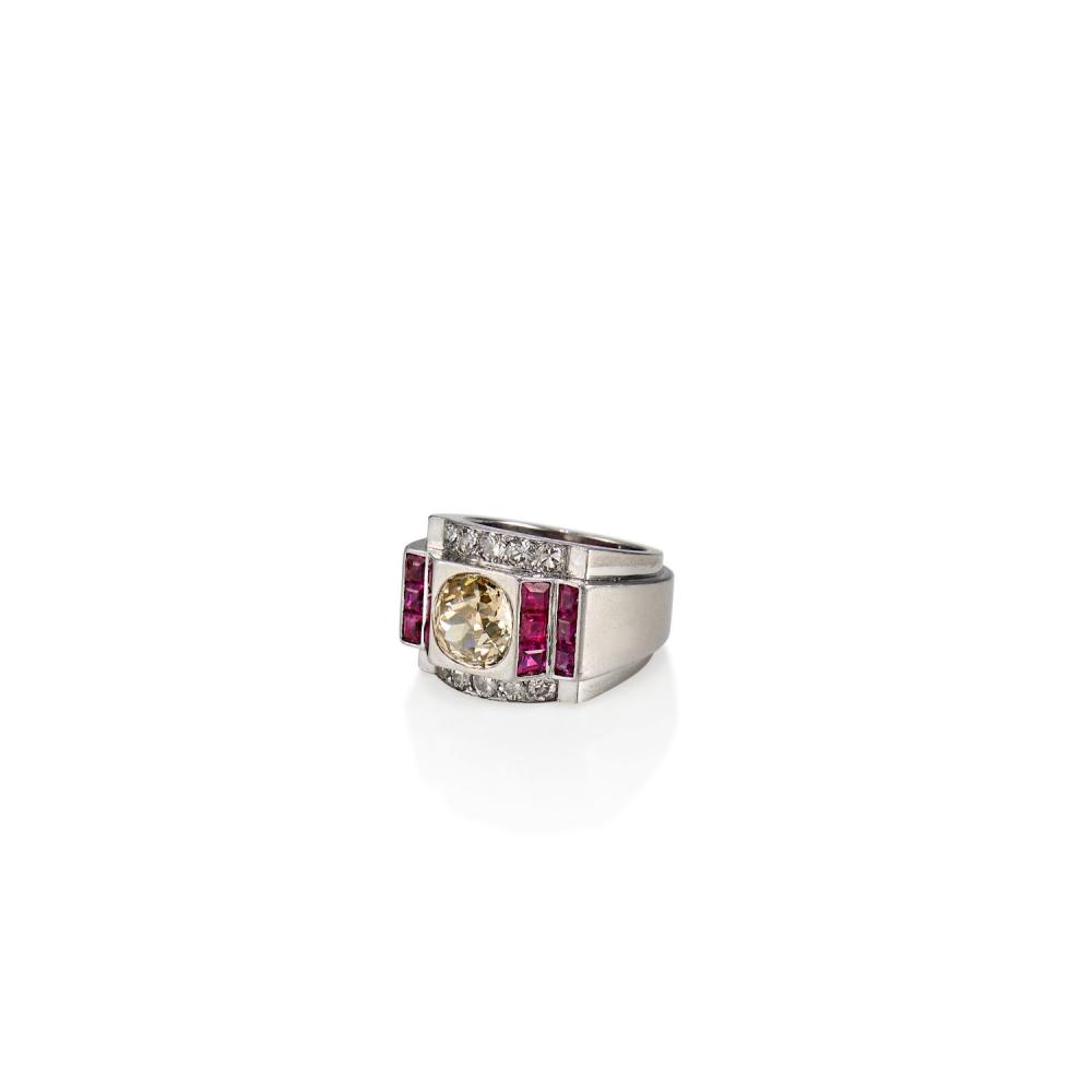 ANNÉES 1930 BAGUE CHEVALIÈRE DIAMANTS ET RUBIS Elle est ornée d'un diamant coussin encadré de gradins soulignés de rubis calibré...