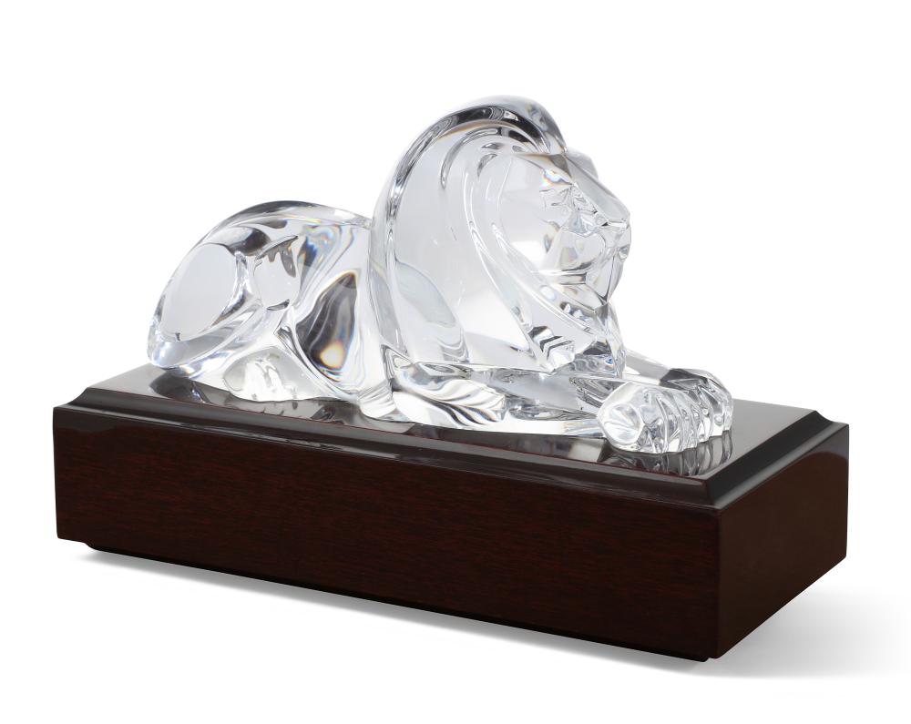 A Steuben clear glass model of a recumbent lion, designed by Lloyd Atkins, issued 1986