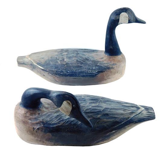 DECOYS: Two Canada geese, one upright and one with head arched over back, metal eyes, painted over weights with scratched illegible...