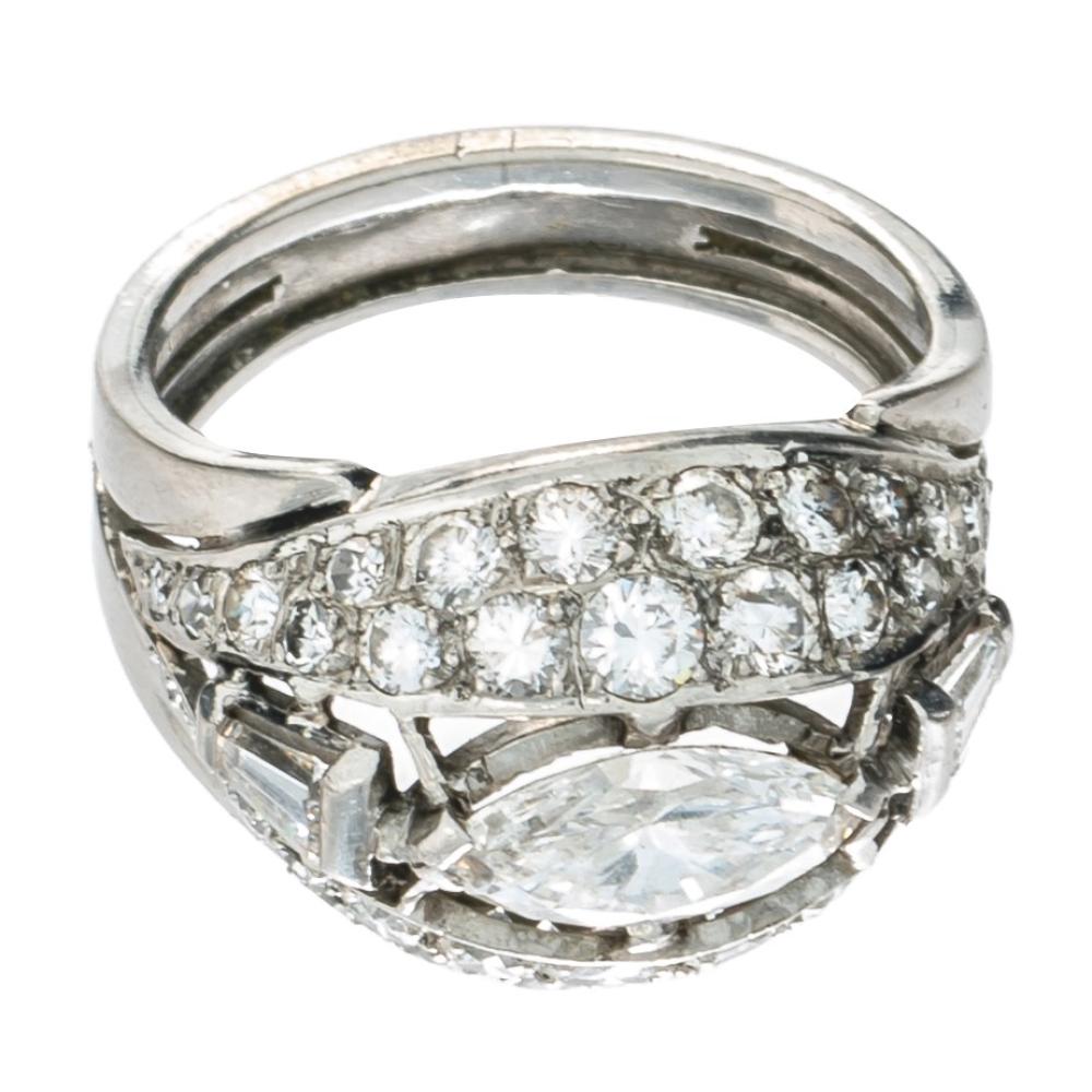 An Art Deco platinum ring, set with a central marquise cut diamond, two tapered baguettes and 36 brilliant cut diamonds, 950/000, weight: 8,15 g