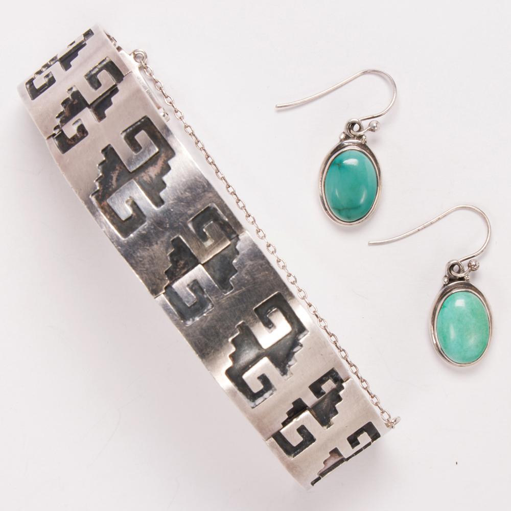 A pair of silver earrings a... image