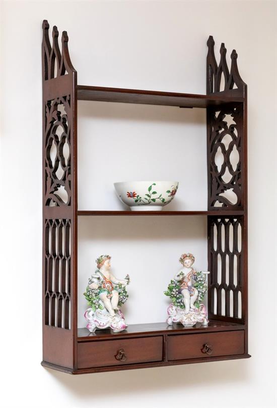 A George III mahogany set of three hanging shelves with lancet shaped tops to the pierced scrolling side supports,