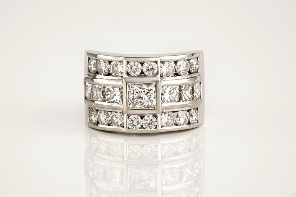 A fine 18ct white gold and diamond ring set with three rows of princess and brilliant cut diamonds,