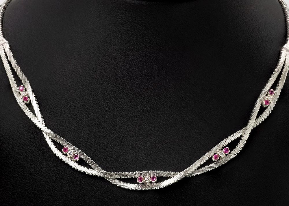 A 14ct white gold, ruby and diamond twist necklace featuring a twisted articulated chain,