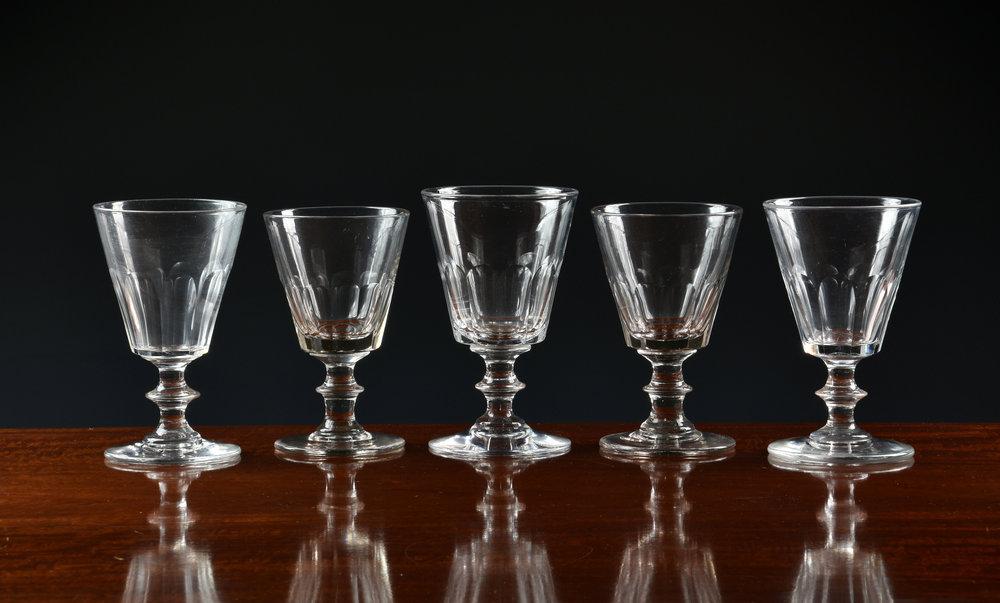 A matched set of ten early to mid-19th century wine glasses the bucket bowls with panel cut decoration,