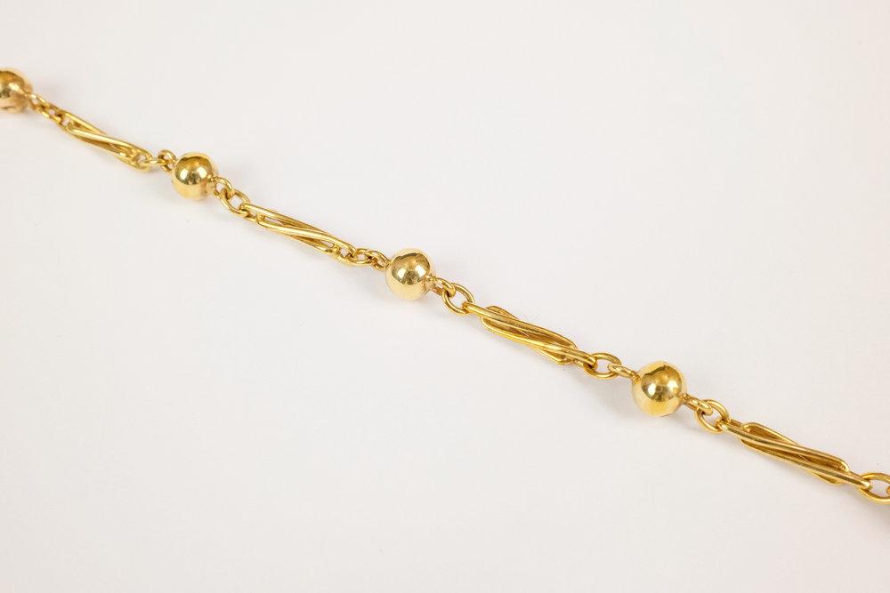 A 9ct gold twisted link and ball bead bracelet measuring approximately 18.5cm in length, with bolt ring clasp.