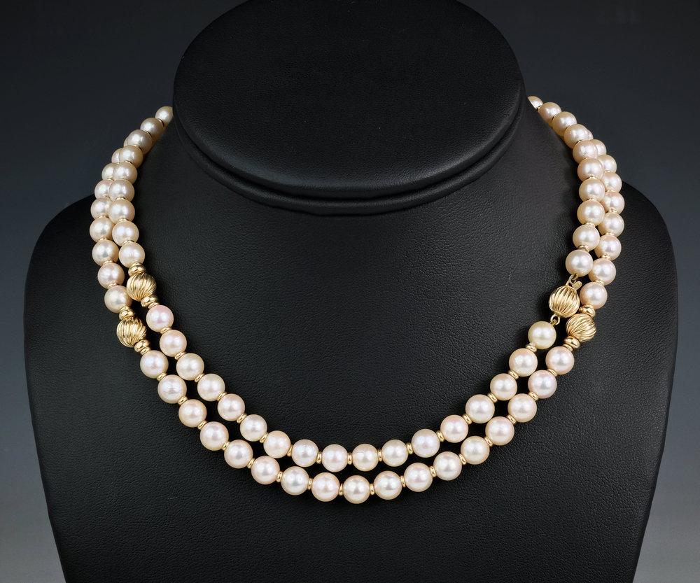 A 9ct gold and pearl opera length necklace featuring 6.5mm pearls with reeded 9ct gold reeded beading and smaller 9ct gold spacers,