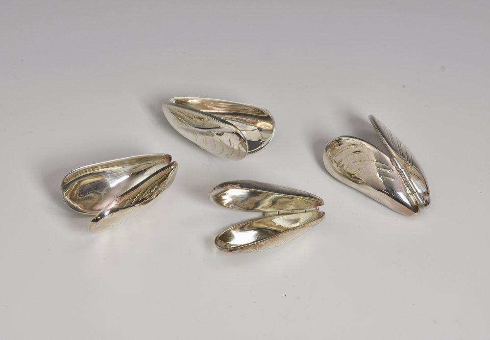 A set of four silver plate Mussel Shell eating pincers fashioned as hinged mussel shells, 2 3/8in. (6cm.) long. (4)