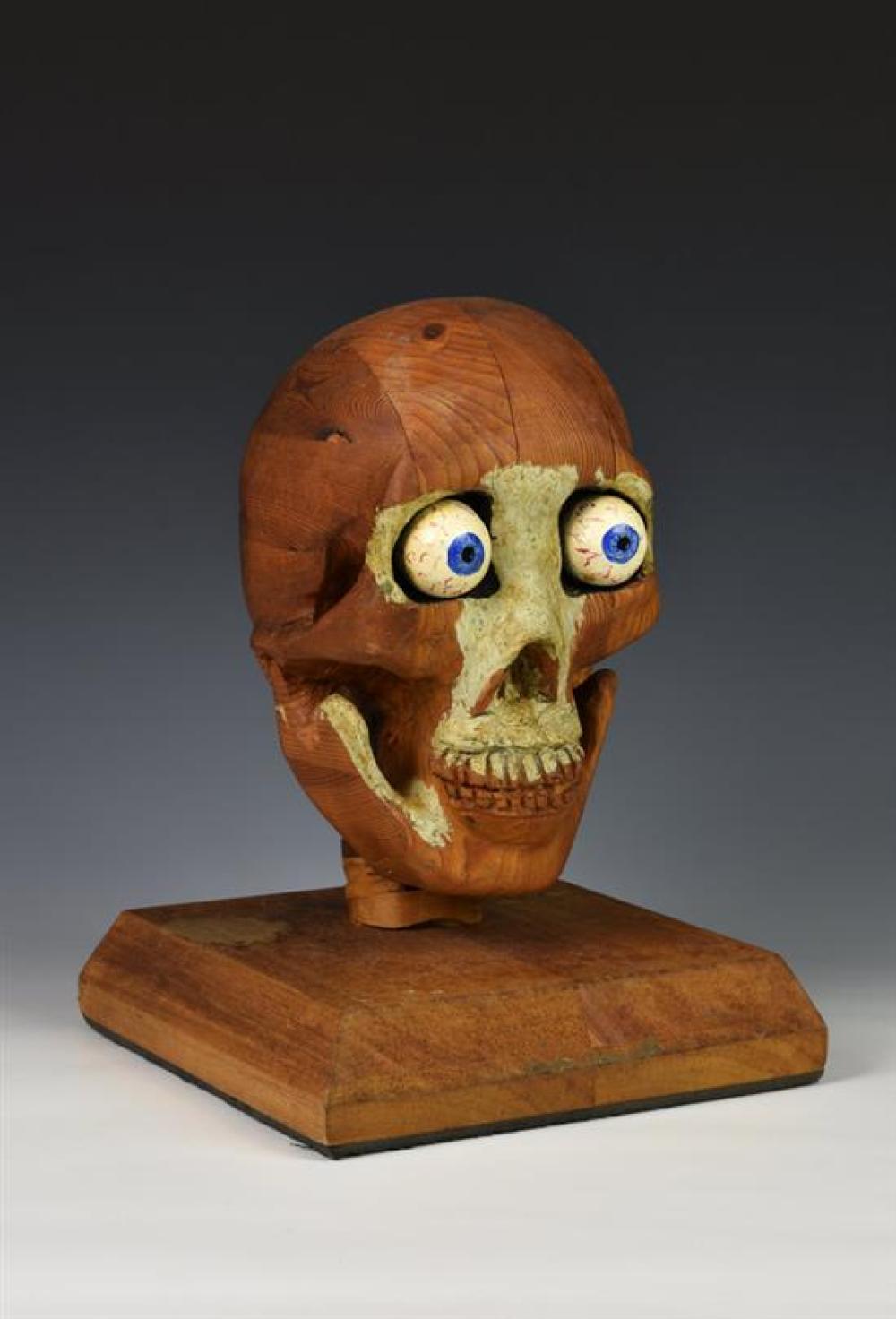 An unusual 20th century carved pine medical / anatomical skeleton skull sectional pine construction with painted goggle eyes,