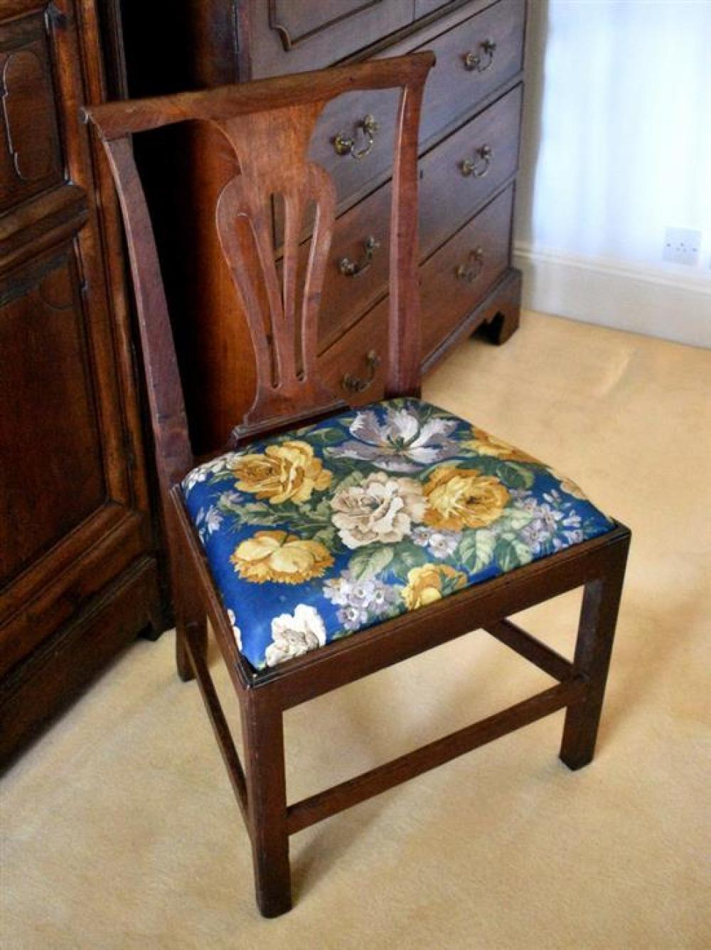 A George III country Chippendale style dining chair the slightly bowed top rail with carved paper scroll terminals,