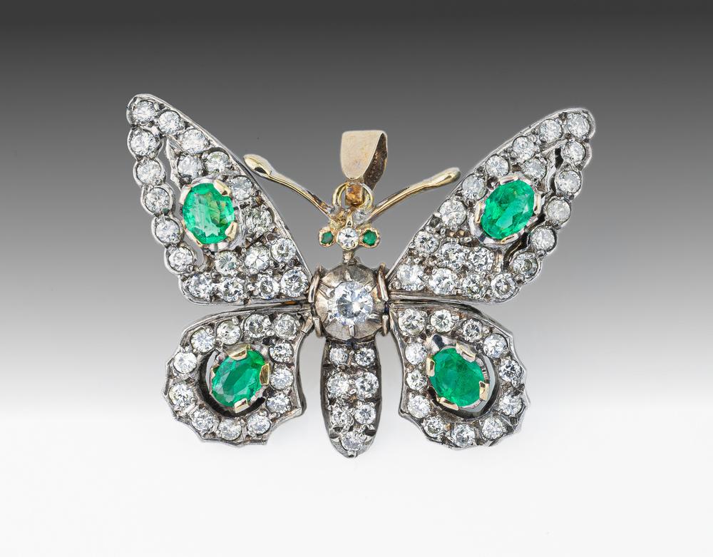 A good antique yellow gold, platinum, emerald and diamond butterfly pendant brooch 1920s, set with four oval cut emeralds to the wings,