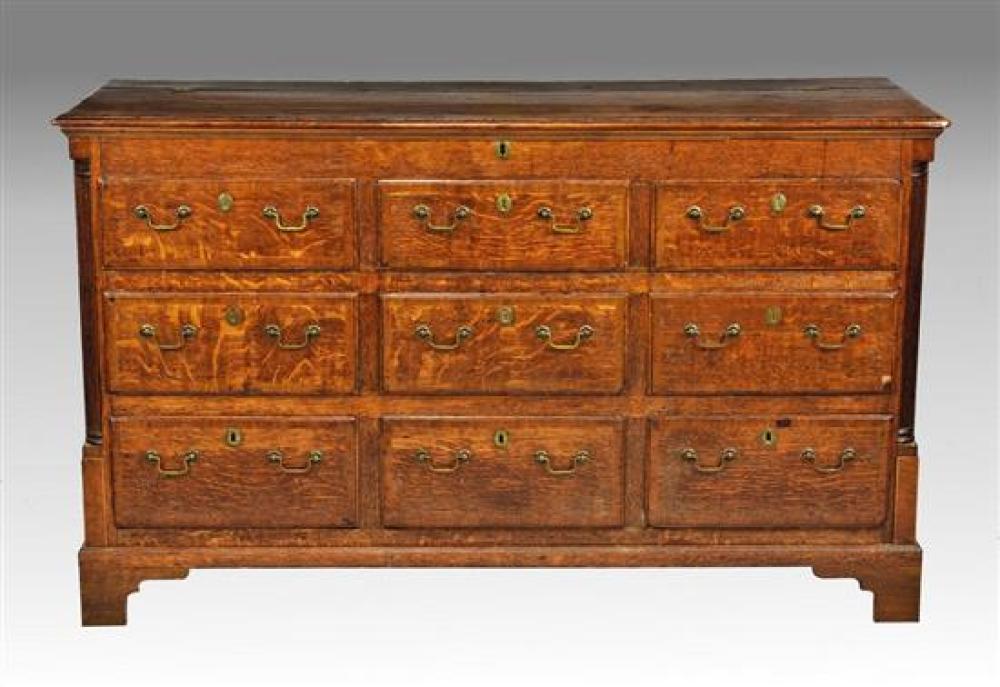 A George III cross banded oak mule chest the moulded and mahogany cross banded three quarter-hinged top with shallow compartment ben...
