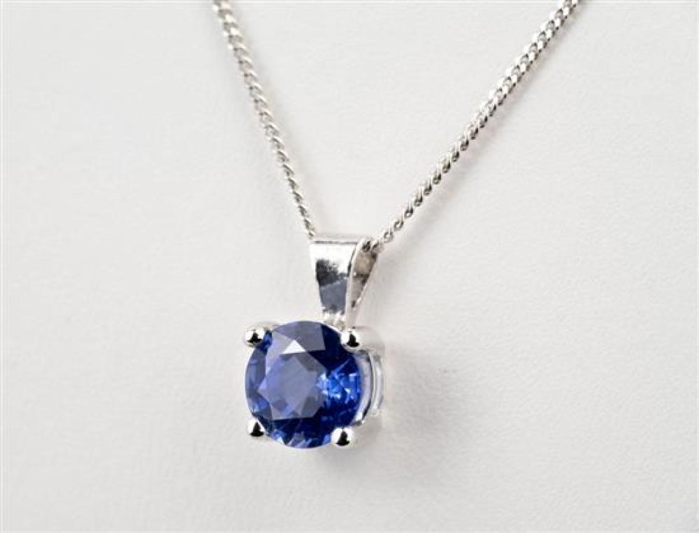An 18ct white gold and sapphire pendant the 1.50ct round cut sapphire in four claw setting, on an 18ct white gold curb link chain.