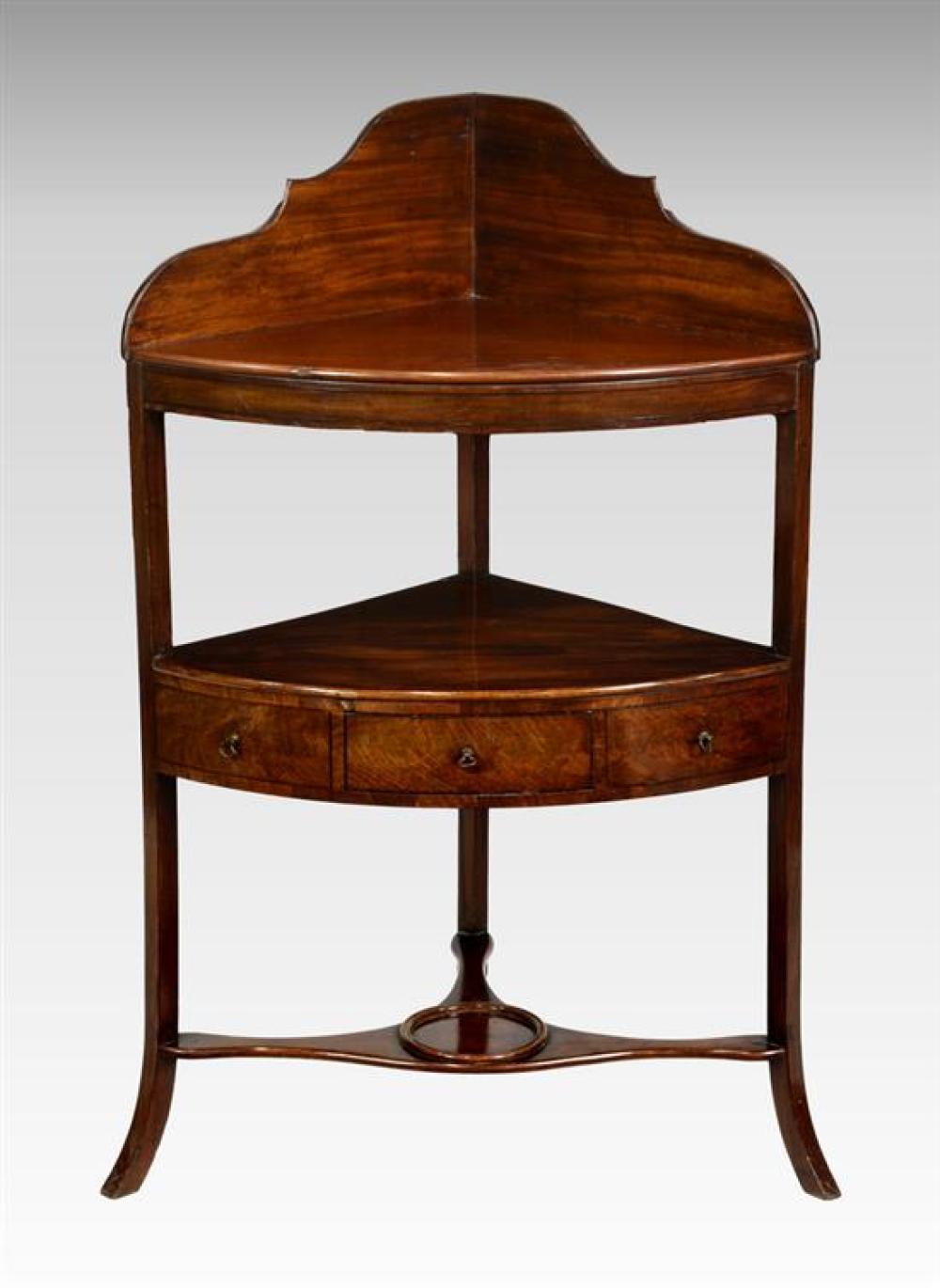 A George III mahogany corner washstand the shaped back over a later bowfront shelf and conforming undertier with single drawer,