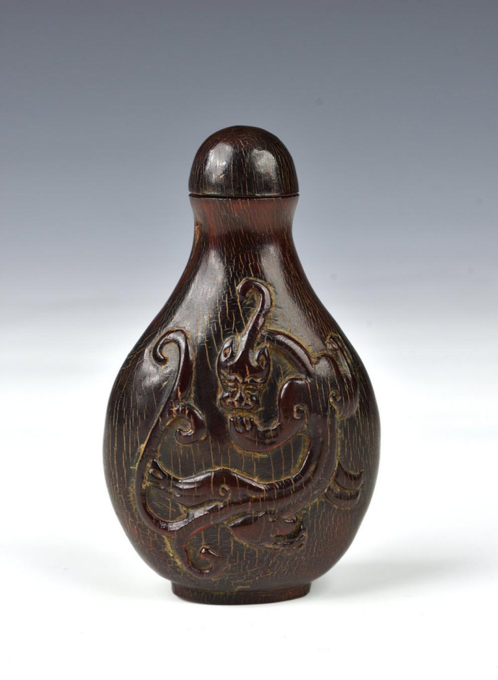 A Chinese carved horn snuff bottle probably 19th century, of flattened baluster form, carved to both sides with a bixie,