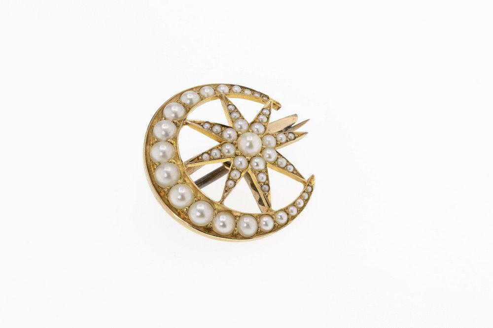 An antique 18ct gold and seed pearl star and moon brooch set with graduated half pearls, 21mm. diameter.