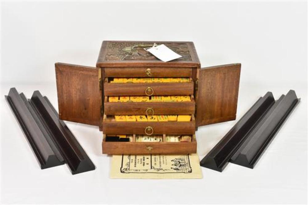 A Chinese hardwood cased Mah Jong set by CHINA EMPORIUM LTD, the top carved with lake scene,